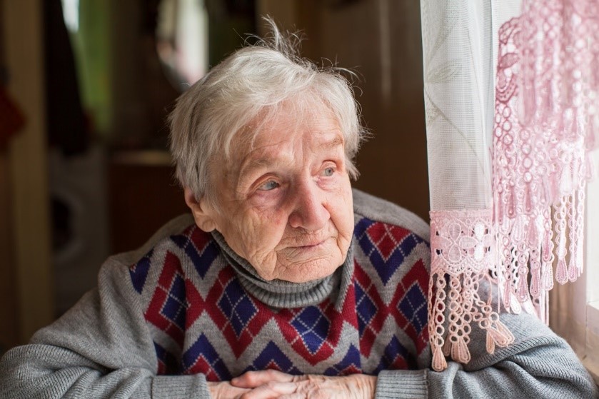 Senior woman sitting at table looking out window