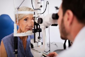 Eye doctor looking into senior woman's eyes