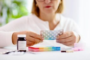 mature woman looking at her medications